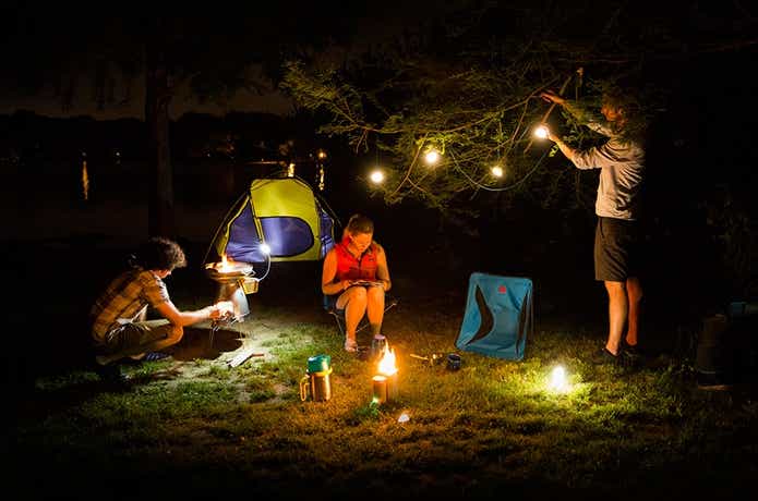 バイオライトで夜のキャンプを楽しむ人々