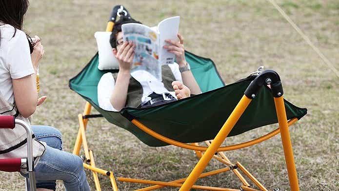 シフラスハンモックに寝そべり本を読む男性