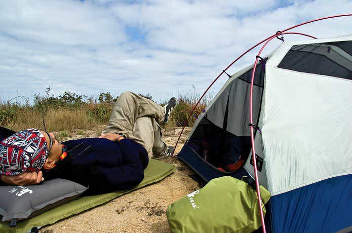 テントの外で寝転ぶ男性