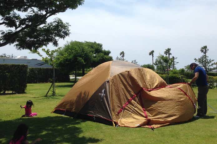 姫キャンプのためにテント設営する父