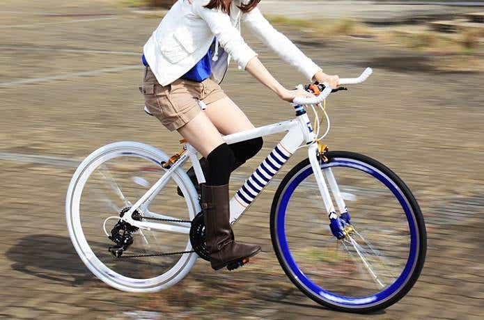 ドッペルギャンガーの自転車で道路を走る女性