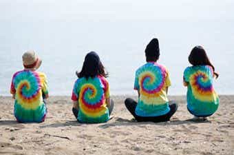 タイダイ染めのTシャツを着た女性4人の後ろ姿