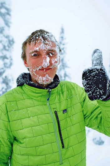パタゴニアのジャケットで雪山を登る男性