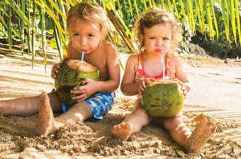ココナッツの実からジュースを飲んでいる子供たち