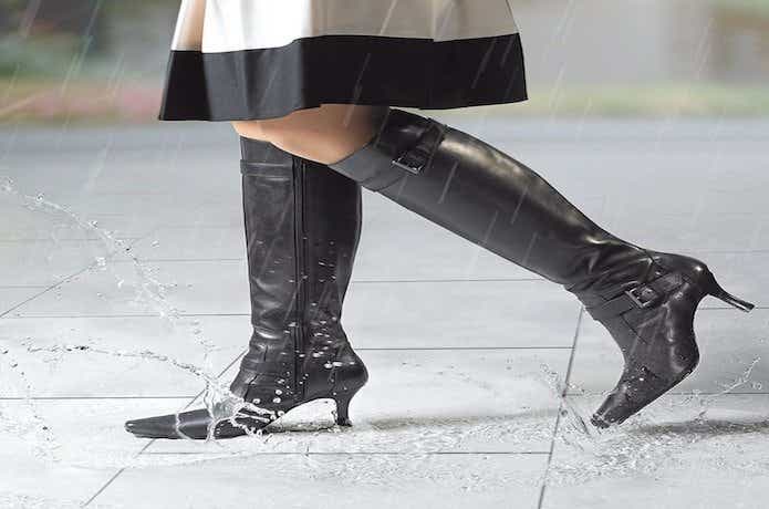 防水スプレーをかけた革靴で雨の中を歩く女性