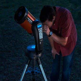 天体望遠鏡をのぞいている男性
