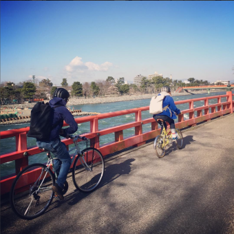 川沿いを自転車で走る人達
