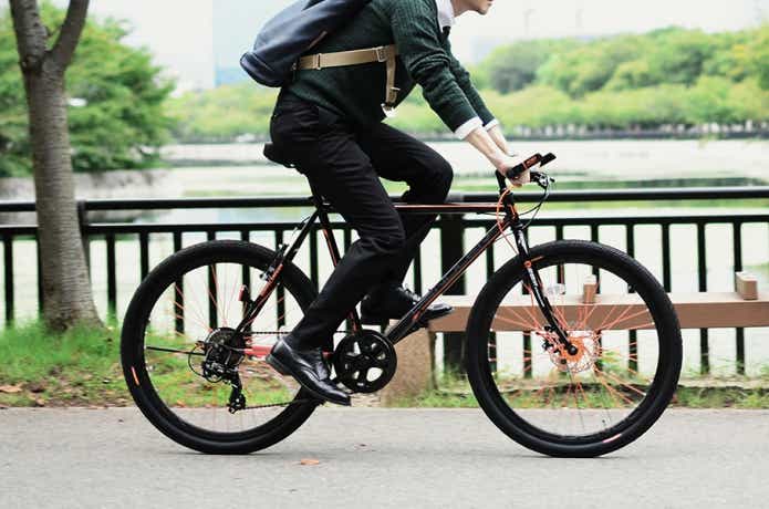 自転車で走る男性のタイヤと公園
