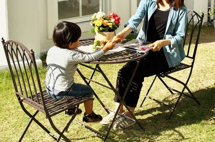 ガーデンチェアに座りながら紅茶を楽しむ親子