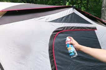 テントに虫よけ機能付きの防水スプレーをする様子