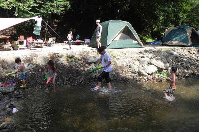 河原、テント、水遊びする子供達