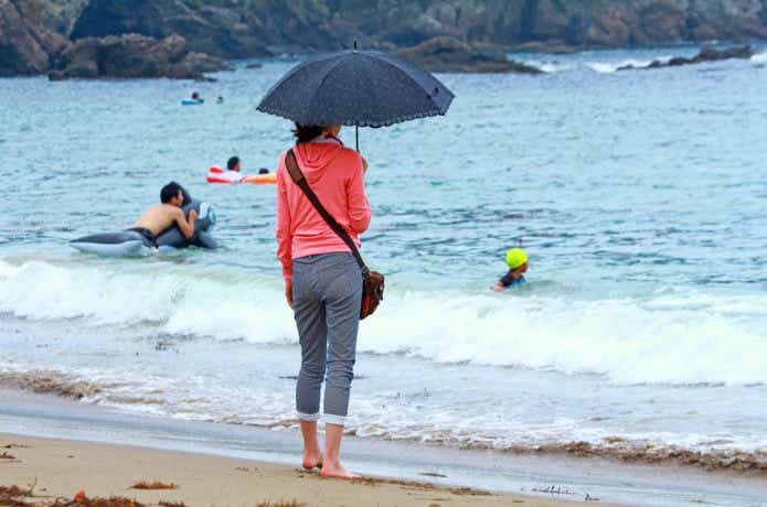 砂浜で傘を差している人