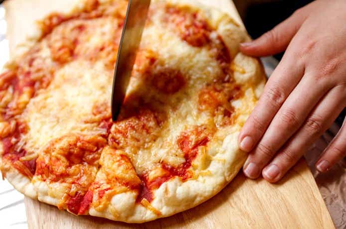 DIYer(s) アウトドアオーブン　まな板の上でピザを切る