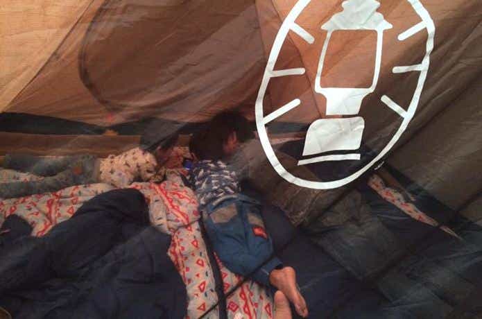 テント内部で寝転んでいる子供たち