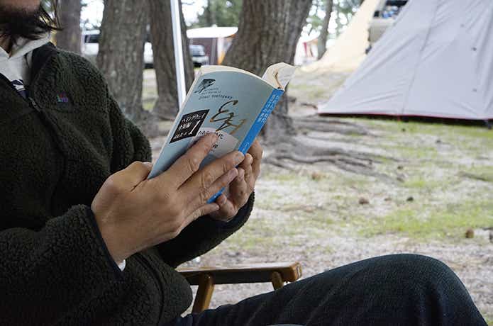 キャンプサイトで読書を楽しむ人
