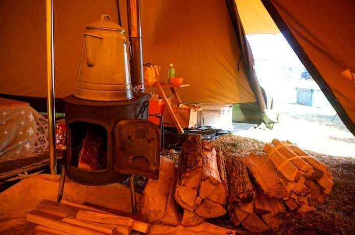 ogawaのちびストーブと薪が置かれたテントの中