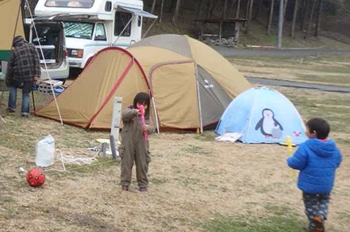 オートキャンプ場に設営されたテントとこどもたち