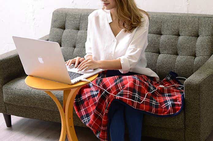 USBブランケットをパソコンを使いながら使用する女性