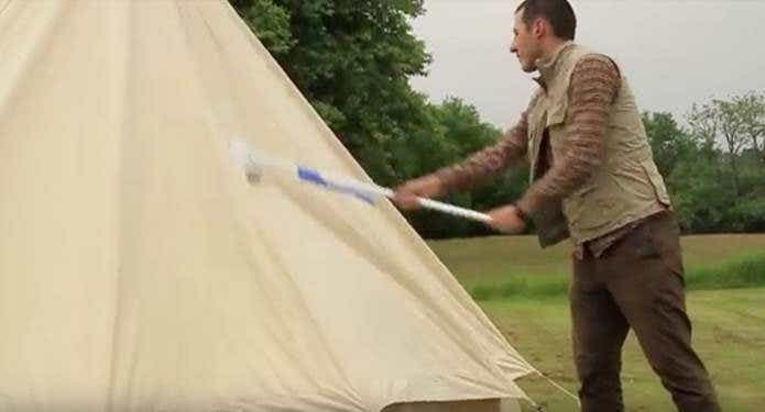 撥水剤をテントに塗布している人