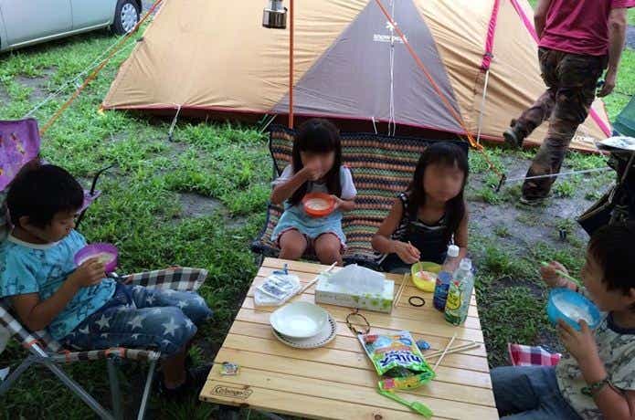 キャンプで子供が食事する様子