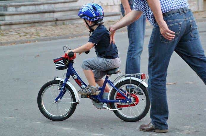 ヘルメットを被って自転車を漕ぐ男の子