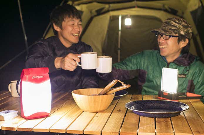 夜のキャンプを楽しむ男性達