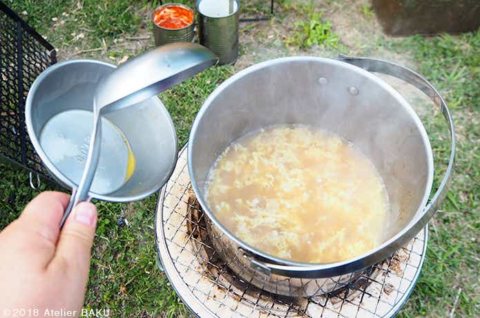 七輪、鍋の中のコーンスープ、おたま、溶き卵を割り入れる