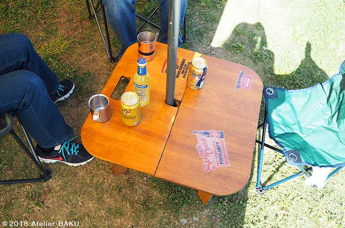 ローテーブル、カクテルの瓶、マグカップ、テーブルを囲む人