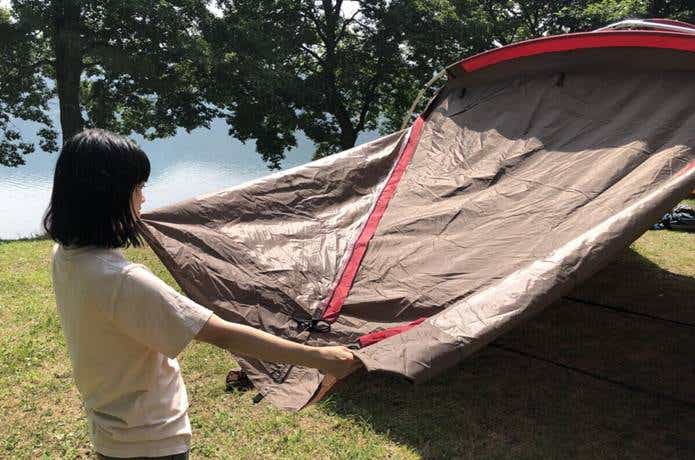 女性がテントを広げている
