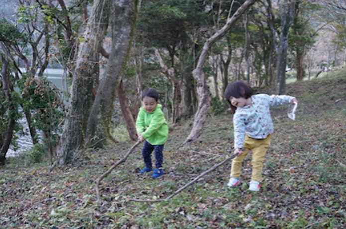 木の枝で遊ぶ子供