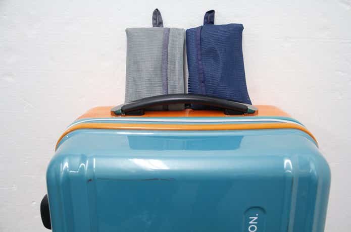 無印良品のそのまま洗える衣類ケース２個がスーツケースの上に畳んで置いてある様子
