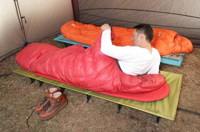 冬キャンプ　コットで寝る男性
