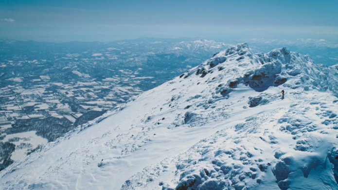 ドローンで撮影した雪山とスキーヤー