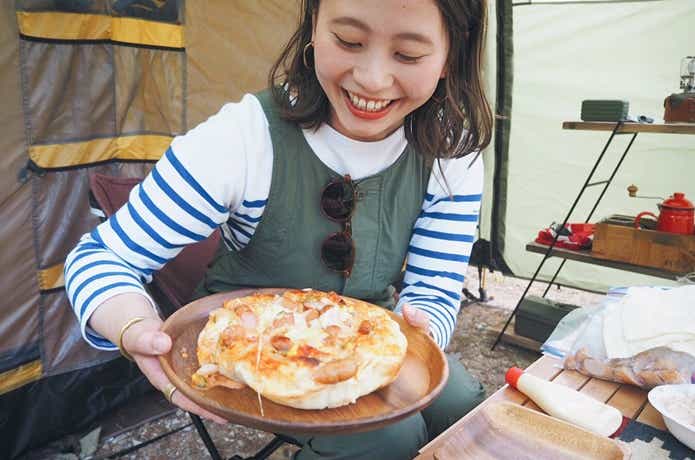 キャンプでピザを作る女性