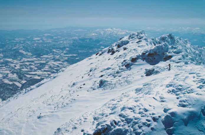 ドローンで撮影した雪山とスキーヤー
