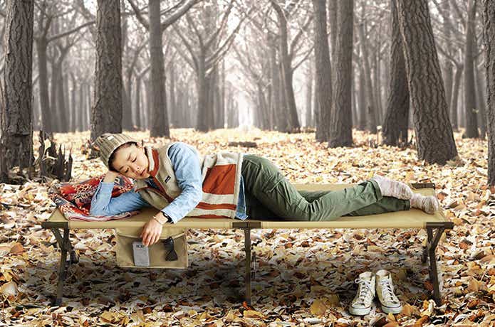 「EASY COT」（イージーコット）を使用して森の中寝る女性