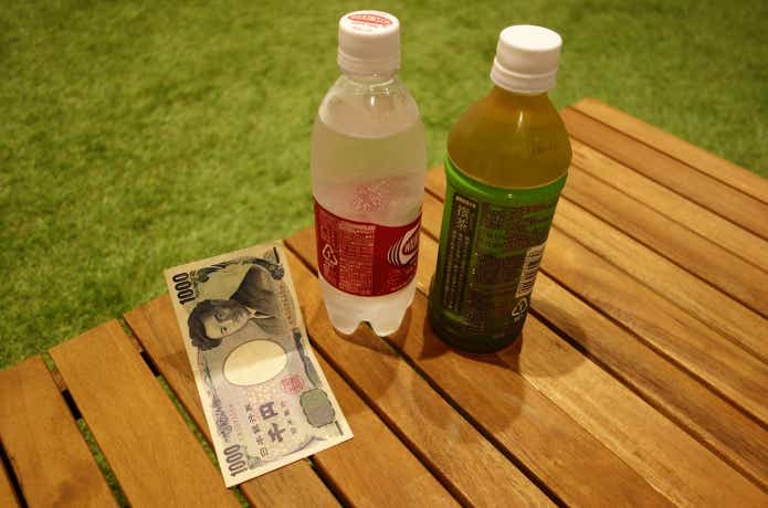 テーブルに置かれた500mlペットボトルと千円札