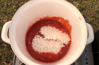 トマト鍋の残り汁に、ご飯とチーズを入れている様子