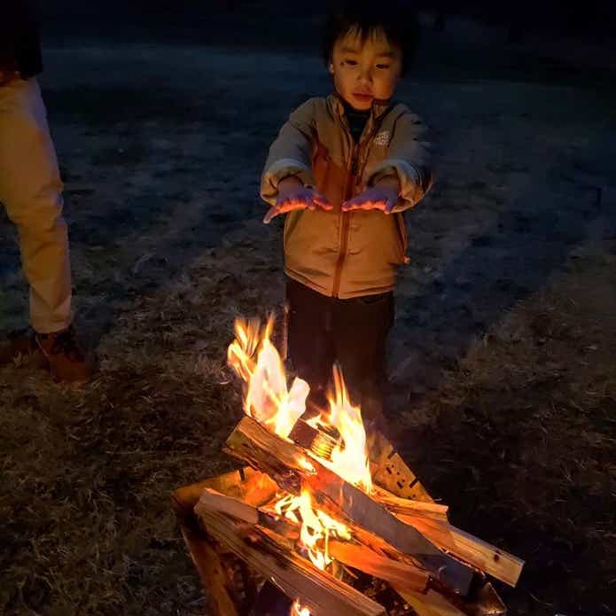 焚き火で暖を取る子供