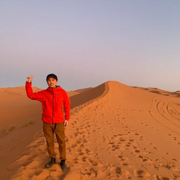 サハラ砂漠に沈む夕日と男性