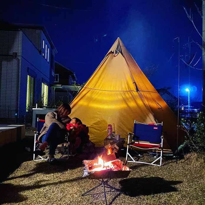 庭に設置したテントでキャンプを楽しむ親子