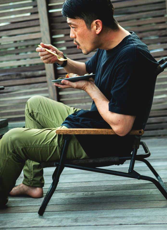 WATERPROOF LEATHER FOLDING CHAIRに座って食事をする男性