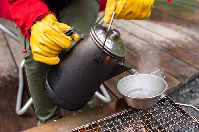 ユニフレームのケトルで沸かしたお湯を食器にそそぐ