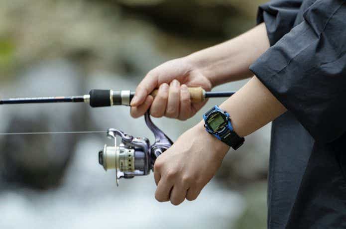 TIMEXの「アトランティス・ヌプシ」を付けて釣り竿を握る人