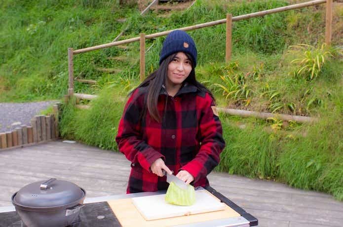 スノーピークのマナイタセットで調理する女性