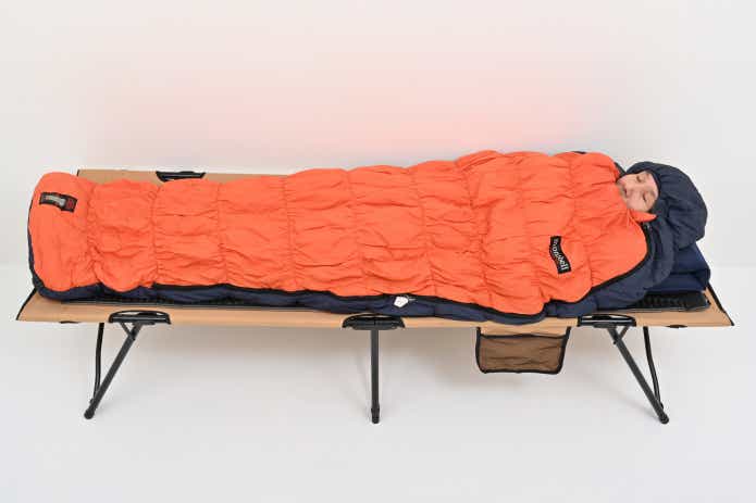 クイックキャンプのフォールディングコットに寝る男性