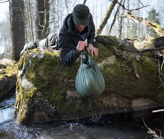 サヴォッタ「ウォーター バッグ」をバケツのように使って水を汲む男性
