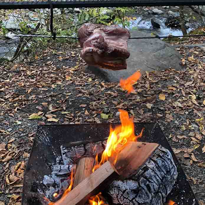 焚き火料理 豚肩ロースの塊を遠火で焼く様子
