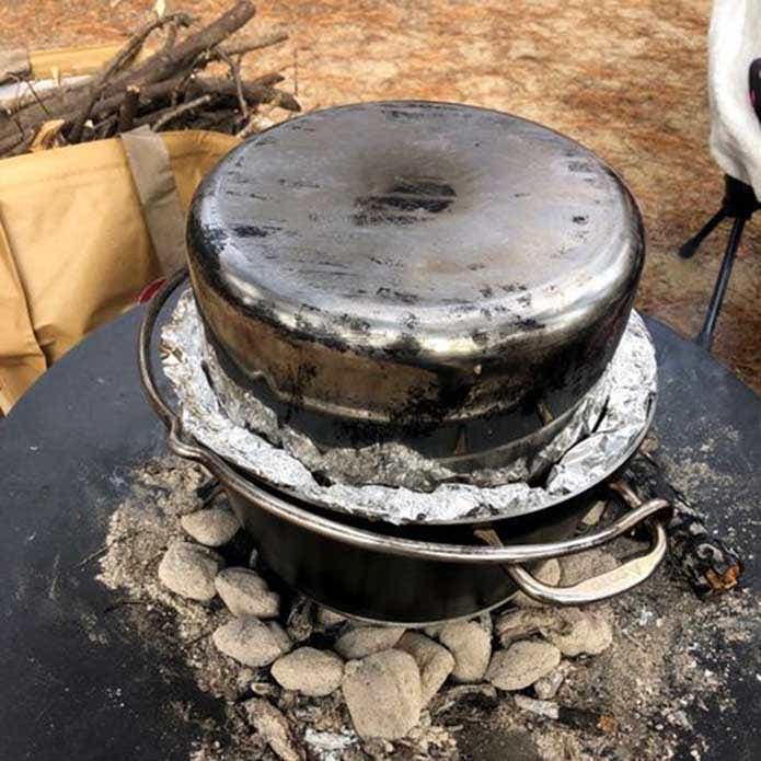 焚き火料理 ビア缶チキン 上から深みのある鍋を被せて隙間をアルミホイルで塞いだ様子