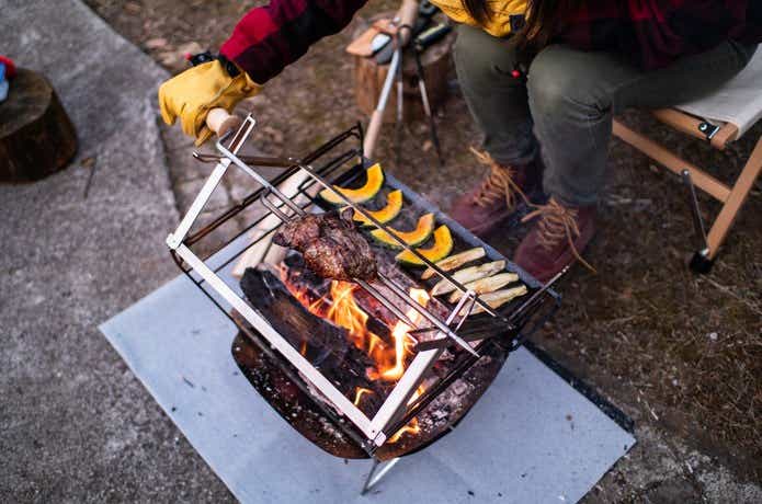 焚き火台で肉を焼いている